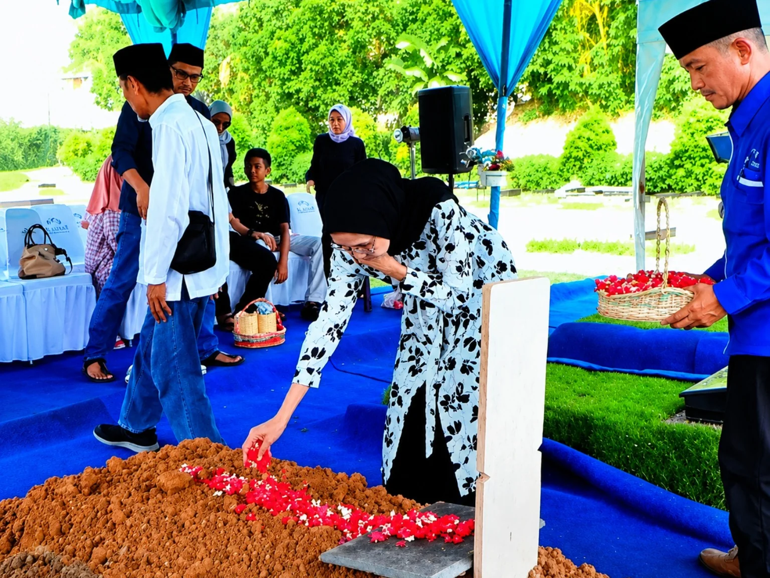 Keluarga menaburkan bunga di makam setelah prosesi pemakaman