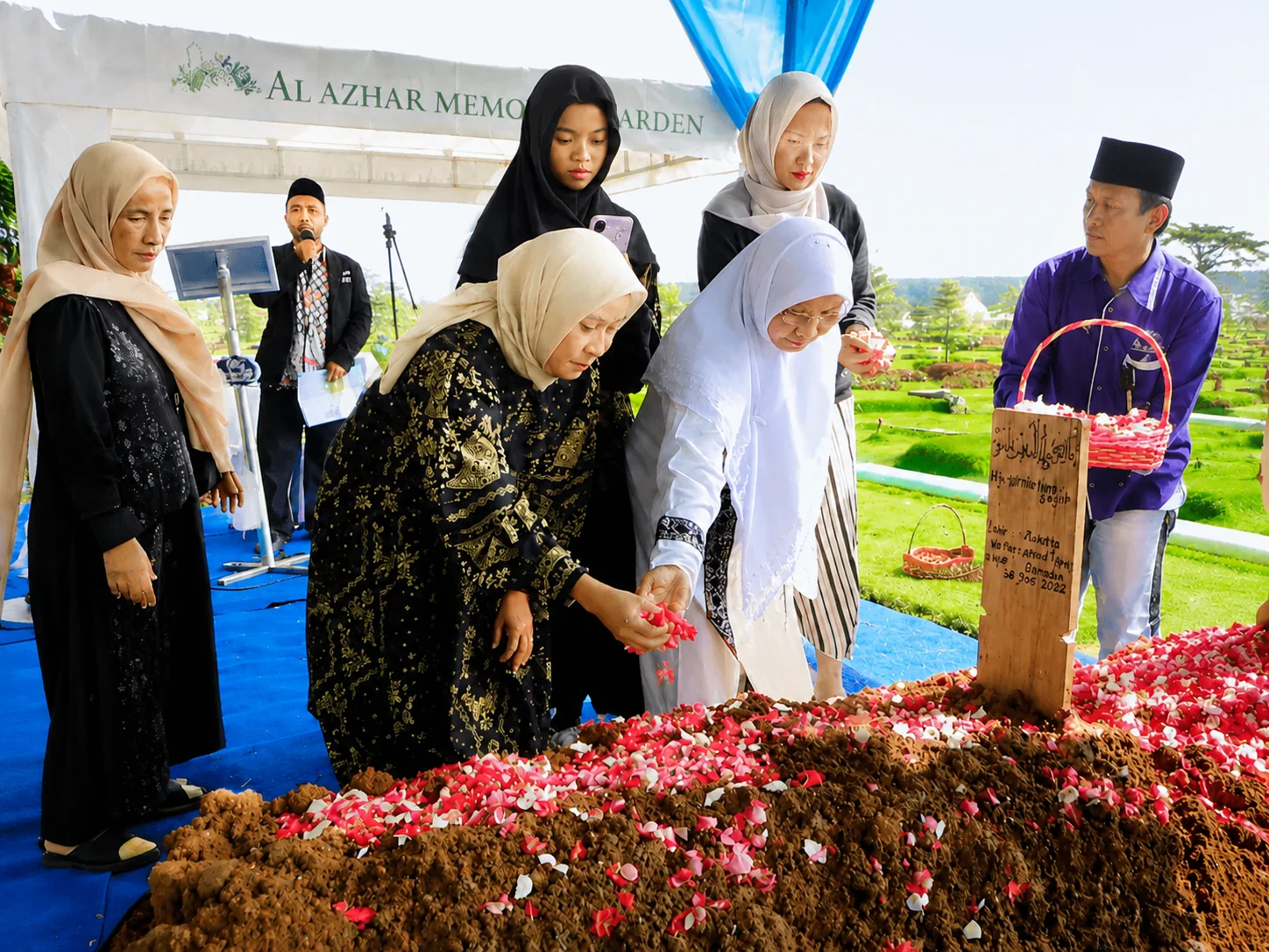 Keluarga menabur bunga dalam prosesi pemakaman di Al Azhar Memorial Garden